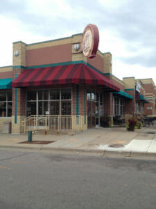 Custom stripes on corner awning with hard valance by Acme Awning in Minneapolis