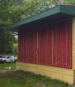 Roll curtains by Acme Awning rolled down on a screen porch in rural Minnesota