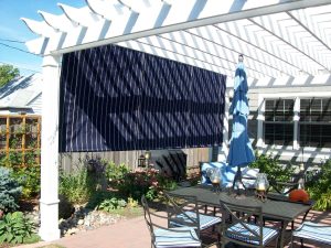 Canvas roll curtain with ropes on a pergola